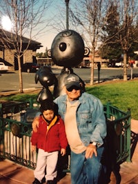 a woman and a child posing for a picture in front of a statue