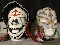 two wwe wrestling masks on top of each other