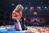 a wrestler is kneeling on the floor in a wrestling ring